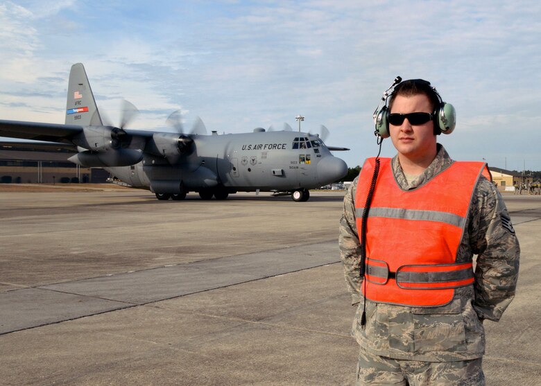 U.S. Air Force Staff Sgt. Justin Simpson, 43rd Aircraft Maintenance Squadron, provides ramp safety observations while an Air Force Reserve Command C-130 Hercules aircraft from the 910th Airlift Wing, Youngstown, Ohio, taxis behind him during 17th Annual Randy Oler Memorial Operation Toy Drop on Dec. 5 at Green Ramp, Pope Army Airfield, Fort Bragg, North Carolina. Operation Toy Drop is the world’s largest combined airborne operation where Soldiers donate a toy to receive a lottery ticket number that are then randomly drawn for an opportunity to train and jump with foreign jumpmasters over Sicily Drop Zone. Foreign jumpmasters from Poland, Italy, Latvia, Germany, Indonesia and the Netherlands participated in this year’s event. Last year, Operation Toy Drop collected more than 12,000 toys that were donated to local charities and organizations across North Carolina. (U.S. Air Force photo/Marvin Krause)