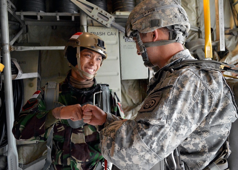 A U.S. Army Soldier from the 82nd Airborne Division fist bumps Indonesian Army Staff Sgt. Thofik Hidayat, a jumpmaster from the 502nd Airborne Battalion, prior to jumping over Sicily Drop Zone, Fort Bragg, North Carolina, during 17th Annual Randy Oler Memorial Operation Toy Drop on Dec. 5. They jumped with other Fort Bragg paratroopers from a U.S. Air Force Reserve C-130H Hercules aircraft from the 440th Airlift Wing. Operation Toy Drop is an annual U.S. Army Civil Affairs and Psychological Operations Command (Airborne) sponsored event. Toy Drop gathers thousands of toys donated by Fort Bragg Soldiers and Pope Airmen and distributes them to local area children who might otherwise not receive a toy during the holidays. A large airborne operation is also part of Toy Drop. Paratroopers will get a chance to train and jump with a jumpmaster from one of six countries participating this year. Foreign jumpmasters from Germany, Indonesia, Italy, Latvia, Netherlands and Poland, participated in this year’s event. This allows them to earn foreign airborne or “jump” wings. (U.S. Air Force photo/Marvin Krause)
