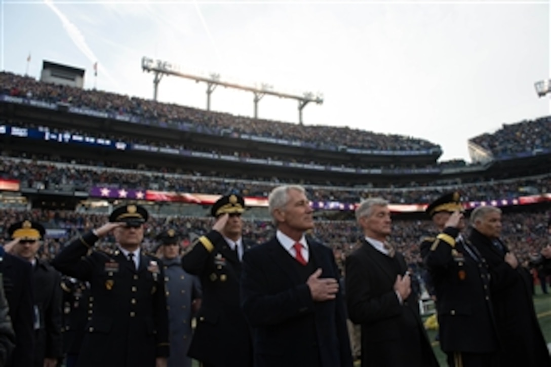 Defense Secretary Chuck Hagel, Army Secretary John McHugh, and other defense leaders listen to the national anthem before the 115th Army-Navy football game at M&T Bank Stadium in Baltimore, Dec. 13, 2014. 