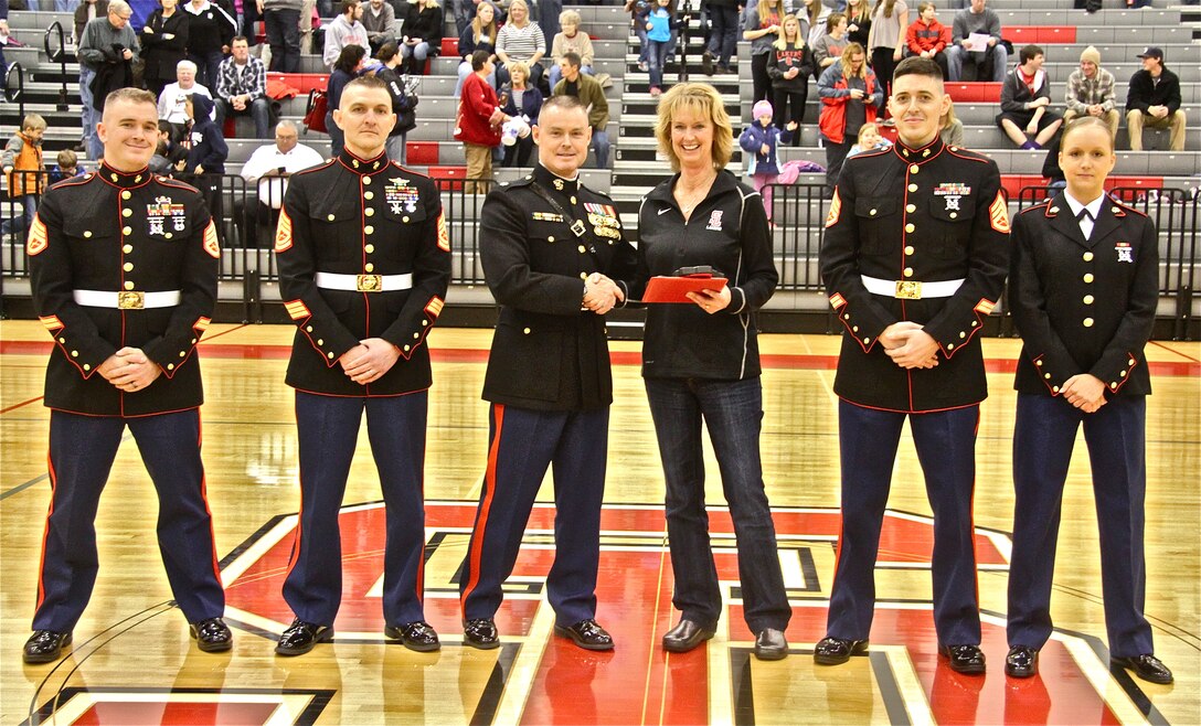 Major Christopher Buck, Commanding Officer of Recruiting Station Lansing, 9th Marine Corps District, presents Sarah Bulthuis, retired Spring Lake varsity volleyball head coach, with the 2013-2014 Recruiting Station Lansing Semper Fidelis Michigan High School Coach of the Year Award. RS Lansing selects one male and one female coach with this award each year for their contributions to their teams, communities and students. Bulthuis retired after 27 years of coaching at Spring Lake, finishing her career with 44 wins in her final season. 