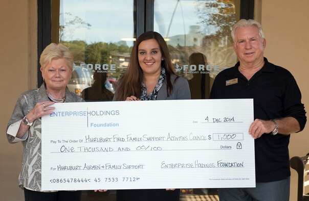 The Airman & Family Readiness Center received a $1,000 donation to support the Hurlburt Family Support Activities Council, Dec. 4, 2014 on Hurlburt Field, Fla. The council is a nonprofit program which assists Air Commandos and their families with financial aid and support by rendering temporary childcare, support movie nights for kids and even the offer an occasional monetary grant to Airmen in need. (U.S. Air Force photo/ Staff Sgt. Kentavist P. Brackin)