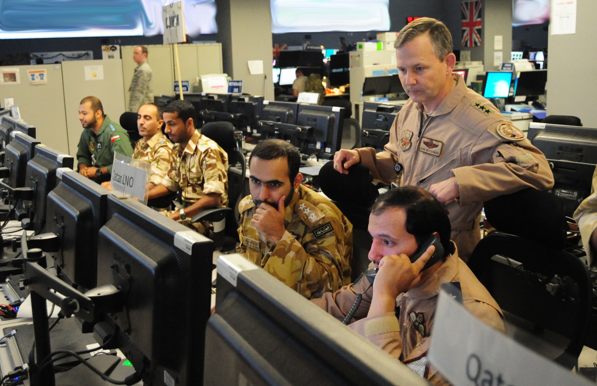 Lt. Gen. John Hesterman III, U.S. Air Forces Central Command commander, looks on as Gulf Cooperation Council Liaison Officers participate in an exercise at the Combined Air Operations Center, Nov. 26, 2014, Al Udeid Air Base, Qater. (U.S. Air Force Photo Illustration by Staff Sgt. Chelsea Browning)