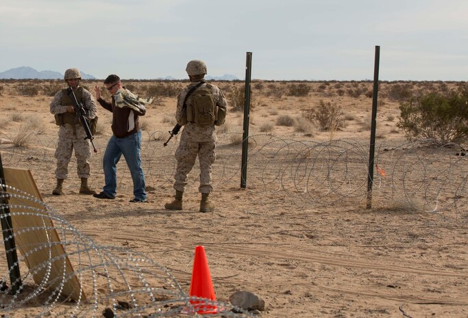 Marines with Marine Wing Support Squadron 371 execute security at the entry and vehicle control point during the security force exercise in support of pre-deployment training Dec. 7-10, 2014, at Auxiliary Landing Field II on Marine Corps Air Station Yuma, Ariz. One of the scenarios the Marines responded to was how to properly detain individuals. (U.S. Marine Corps photo by Cpl. Reba James/Released)
