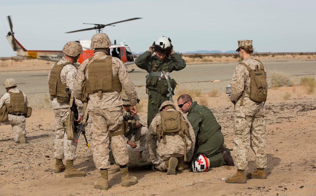 Marines with Marine Wing Support Squadron 371 and a team from Search and Rescue with Headquarters and Headquarters Squadron pick up a casualty during the security force exercise in support of pre-deployment training Dec. 7-10, 2014, at the Auxiliary Landing Field II on Marine Corps Air Station Yuma, Ariz. Casualty evacuations were a realistic scenario that Marines learned to work through and respond as they conducted perimeter patrols. (U.S. Marine Corps photo by Cpl. Reba James/ Released)
