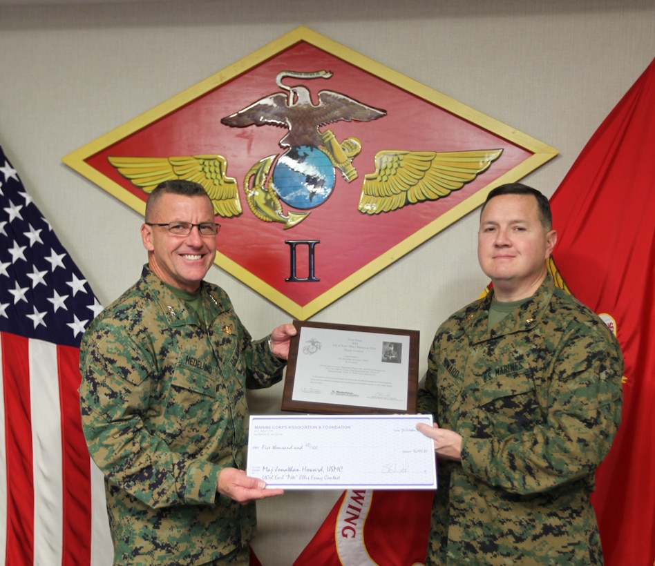Maj. Gen. Robert F. Hedelund presents the 3rd Annual Lt. Col. Earl “Pete” Ellis Essay Contest award to Maj. Jonathan Howard during an award ceremony at Marine Corps Air Station Cherry Point, N.C., Dec. 11, 2014. The contest was sponsored by the Marine Corps Association and Foundation and the Marine Corps Gazette. For his first place essay, “Force Optimization, Regional Alignment and Naval Integration, How the Marine Corps can implement the vision of Expeditionary Force 21 with fewer resources,” Howard earned $5,000, an engraved plaque and publication in the February 2015 issue of the Gazette. Hedelund is the commanding general of 2nd Marine Aircraft Wing and Howard is a Marine Air-Ground Task Force planner with 2nd MAW. 