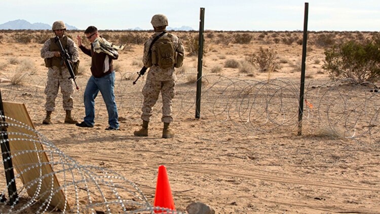Marines with Marine Wing Support Squadron 371 execute security at the entry and vehicle control point during the security force exercise in support of pre-deployment training Dec. 7-10, 2014, at Auxiliary Landing Field II on Marine Corps Air Station Yuma, Ariz. One of the scenarios the Marines responded to was how to properly detain individuals. (U.S. Marine Corps photo by Cpl. Reba James/Released)