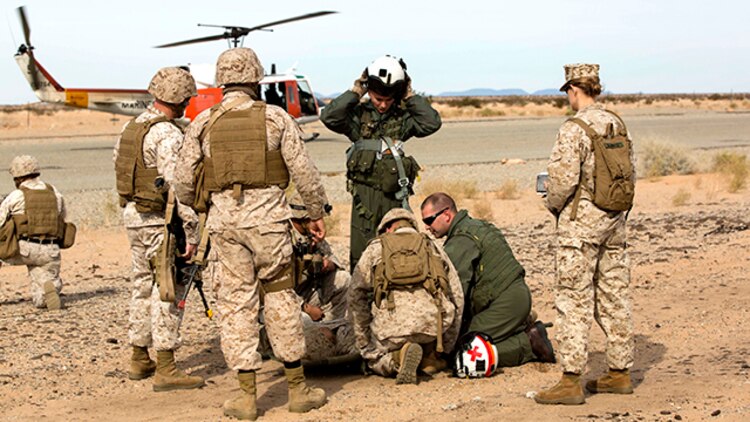 Marines with Marine Wing Support Squadron 371 and a team from Search and Rescue with Headquarters and Headquarters Squadron pick up a casualty during the security force exercise in support of pre-deployment training Dec. 7-10, 2014, at the Auxiliary Landing Field II on Marine Corps Air Station Yuma, Ariz. Casualty evacuations were a realistic scenario that Marines learned to work through and respond as they conducted perimeter patrols. (U.S. Marine Corps photo by Cpl. Reba James/ Released)