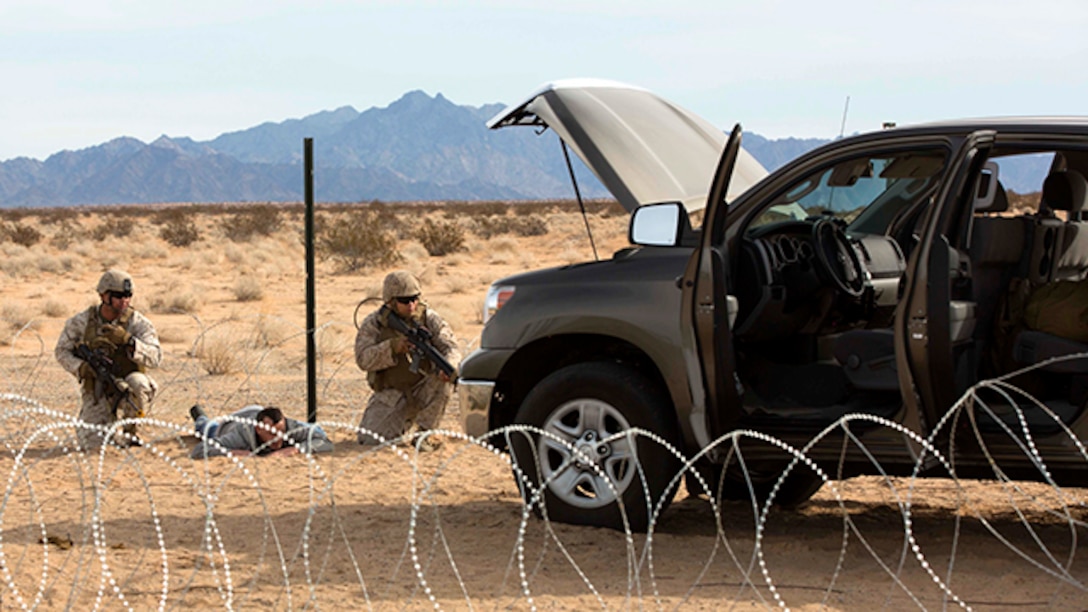 Marines with Marine Wing Support Squadron 371 carry out security at the entry and vehicle control point during the security force exercise in support of pre-deployment training Dec. 7-10, 2014, at Auxiliary Landing Field II on Marine Corps Air Station Yuma, Ariz. The exercise educated the Marines in the fundamentals of installation security and detainment situations. (U.S. Marine Corps photo by Cpl. Reba Jame/Released)