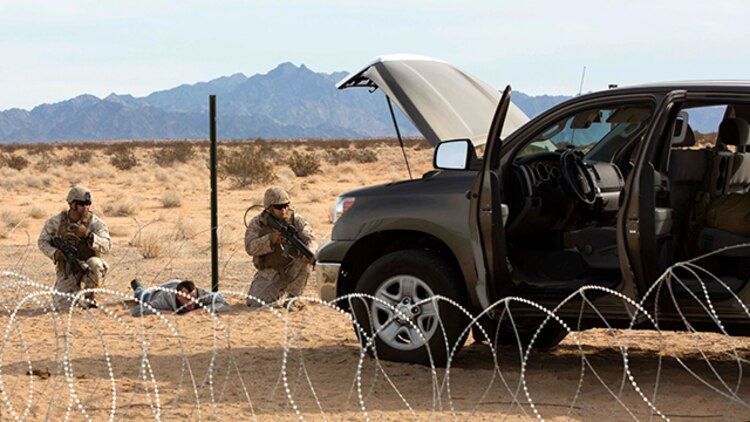 Marines with Marine Wing Support Squadron 371 carry out security at the entry and vehicle control point during the security force exercise in support of pre-deployment training Dec. 7-10, 2014, at Auxiliary Landing Field II on Marine Corps Air Station Yuma, Ariz. The exercise educated the Marines in the fundamentals of installation security and detainment situations. (U.S. Marine Corps photo by Cpl. Reba Jame/Released)