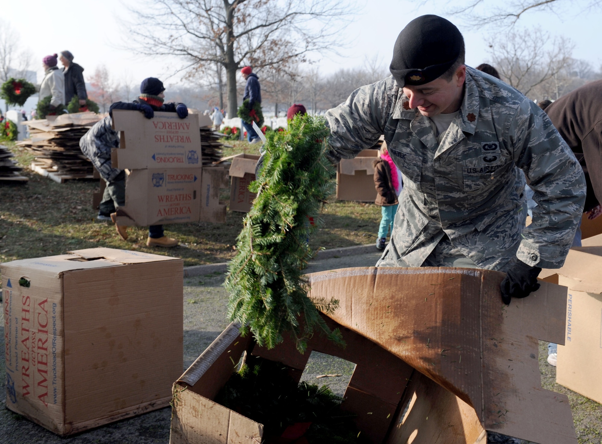 Maj. Michael Hayek unpacks wreaths from a box during the 23rd Annual National Wreaths Across America Day Dec. 13, 2014, at Arlington National Cemetery, Virginia. Hayek, the close air support branch chief and the air liaison officer career field manager at the Pentagon, was one of the nearly 50,000 volunteers at Arlington. (U.S. Air Force photo/Staff Sgt. Christopher Gross)