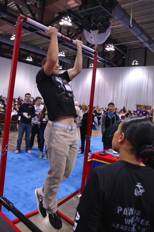 ROCHESTER N.Y. – Dalton Elias, a member of the West Genesee High School Wind Ensemble, pulls with all his might to get 20 pull-ups at the Marine Music Program booth during the New York State School Music Association 79th Annual Winter Conference in Rochester, N.Y. Dec. 6, 2014. The Conference enabled Marines from 1st Marine Corps District, Eastern Recruiting Region, Marine Corps Recruiting Command to meet with high school students and musicians and answer questions about the Marine Music Program. (Official U.S. Marine Corps photo by Sgt. Christopher O’Quin/Released)