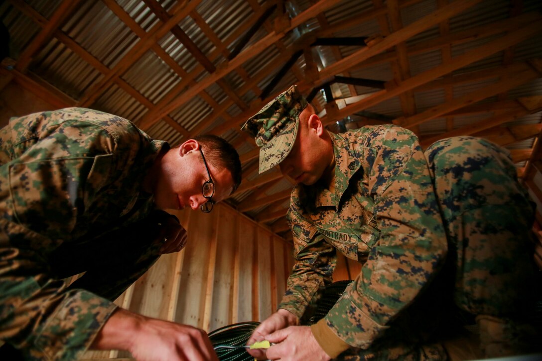 U.S. Marine Cpl. Michael Beck, left, and Sgt. Richard Contrady prepare wires for installation in a Southwest Asia hut during realistic urban training aboard Fort Hunter Liggett, Calif., Dec. 14, 2014. Beck and Contrady are combat engineers with Combat Logistics Battalion 15, 15th Marine Expeditionary Unit. RUT prepares the 15th MEU's Marines for their upcoming deployment, enhancing their combat skills in environments similar to those they may find in future missions. (U.S. Marine Corps photo by Sgt. Jamean Berry/Released)
