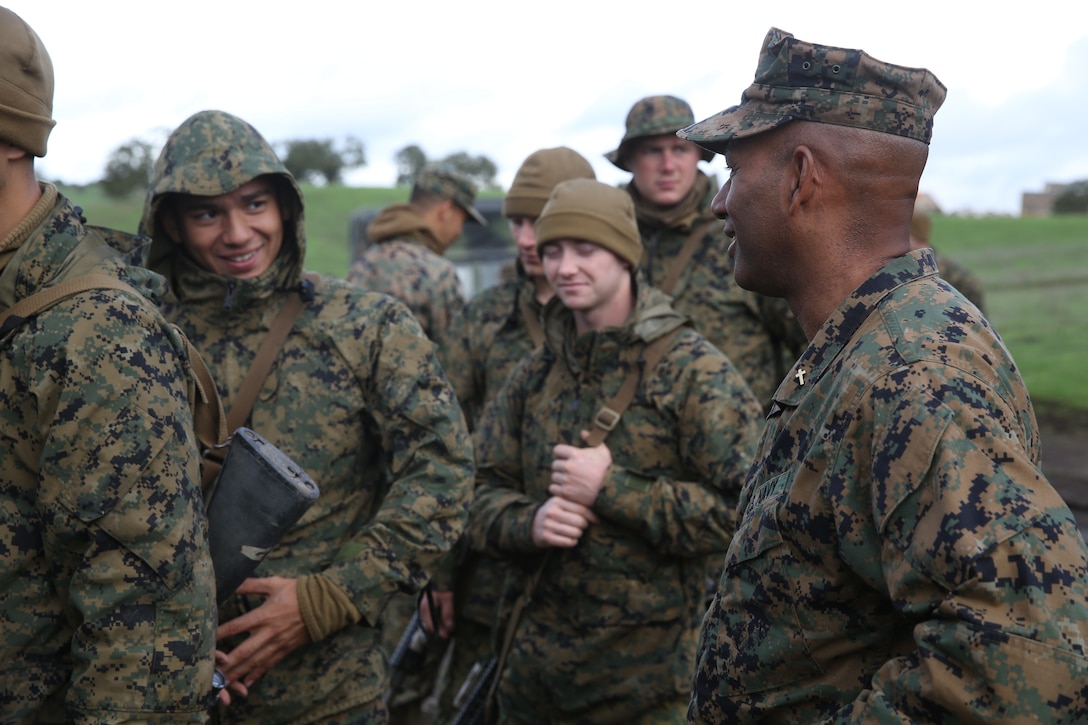 U.S. Navy Commander Samuel Ravelo visits U.S. Marines with Headquarters and Service Company, Battalion Landing Team 3rd Battalion, 1st Marine Regiment, during realistic urban training aboard Camp Roberts, Calif., Dec. 12, 2014. Ravelo is the chaplain of the 15th Marine Expeditionary Unit. The purpose of RUT is to provide the MEU the opportunity to conduct training in unfamiliar environments in preparation for their upcoming deployment. (U.S. Marine Corps photo by Cpl. Anna Albrecht/ Released)