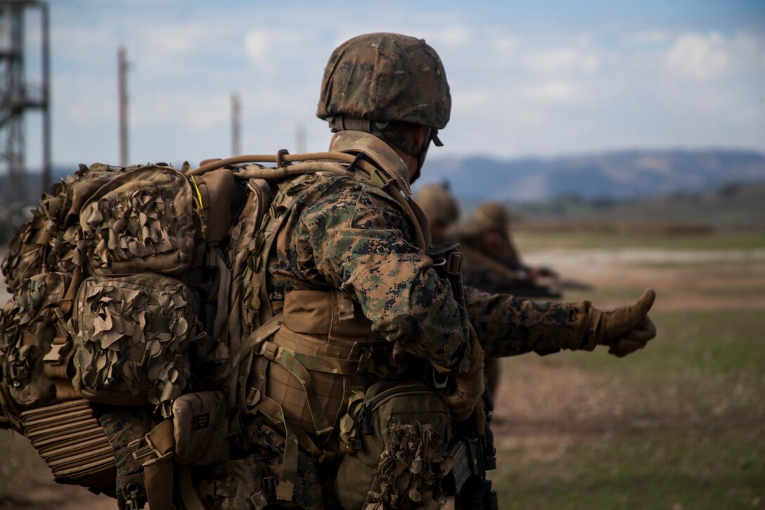 U.S. Marines with Weapons Company, Battalion Landing Team 3rd Battalion, 1st Marine Regiment, 15th Marine Expeditionary Unit, give hand signals during realistic urban training aboard Camp Roberts, Calif., Dec. 14, 2014. RUT prepares the 15th MEU’s Marines for their upcoming deployment, enhancing their combat skills in environments similar to those they may find in future missions. (U.S. Marine Corps photo by Cpl. Elize McKelvey/Released)