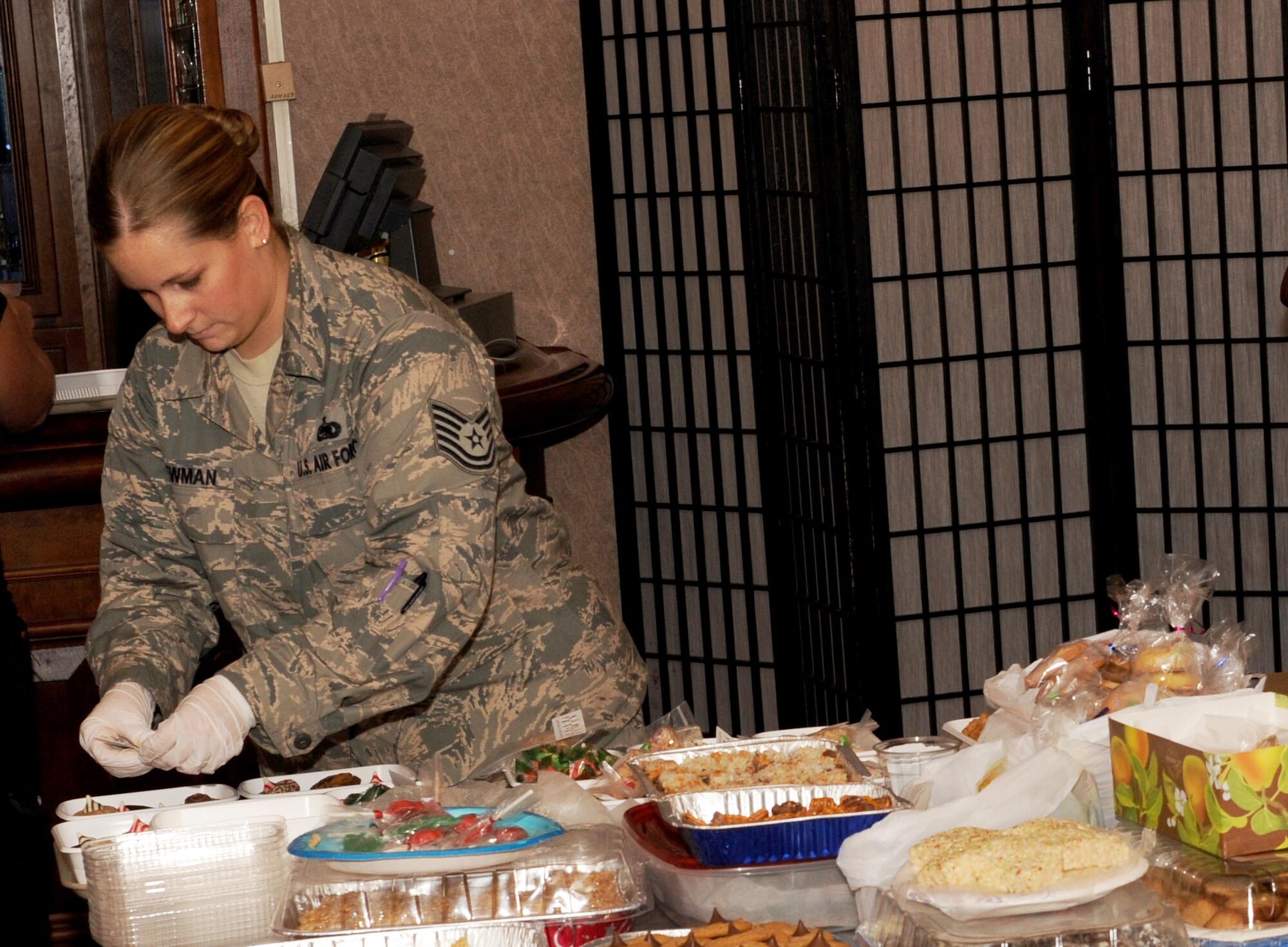 Tech Sgt. Rachel Newman, a cookie drive volunteer from the 353rd Special Operations Maintenance Squadron, packages cookies during the holiday cookie drive on Kadena Air Base, Japan, Dec. 9, 2014. The holiday cookie drive is an annual event coordinated entirely by volunteers. Each year, thousands of cookies are donated and packaged for delivery to the single service members living in dormitories on Kadena. (U.S. Air Force photo by Airman 1st Class Zade C. Vadnais)