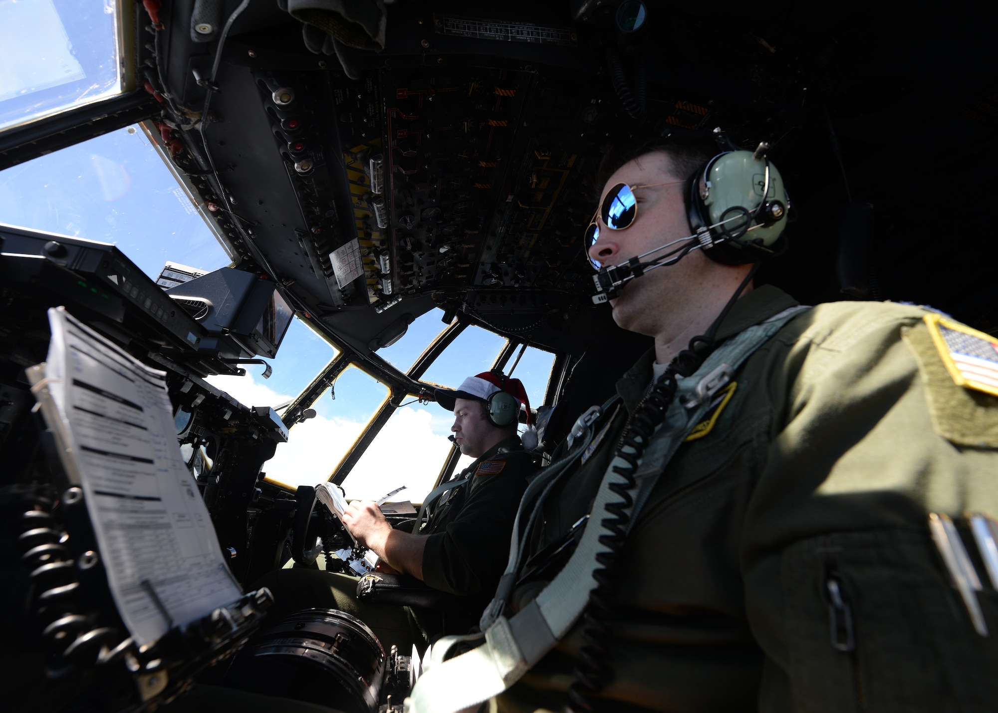 C-130 Hercules pilots from Yokota Air Base, Japan, looks out over the Pacific Ocean while on an Operation Christmas Drop flight Dec. 11, 2014. Operation Christmas Drop, which has occurred since 1952, is the world’s longest humanitarian airlift mission. Each year the operation supplies residents from more than 50 islands with boxes that contain donations to include non-perishable food items, clothing, medical supplies, tools, toys and other various items. (U.S. Air Force photo by Senior Airman Katrina M. Brisbin)