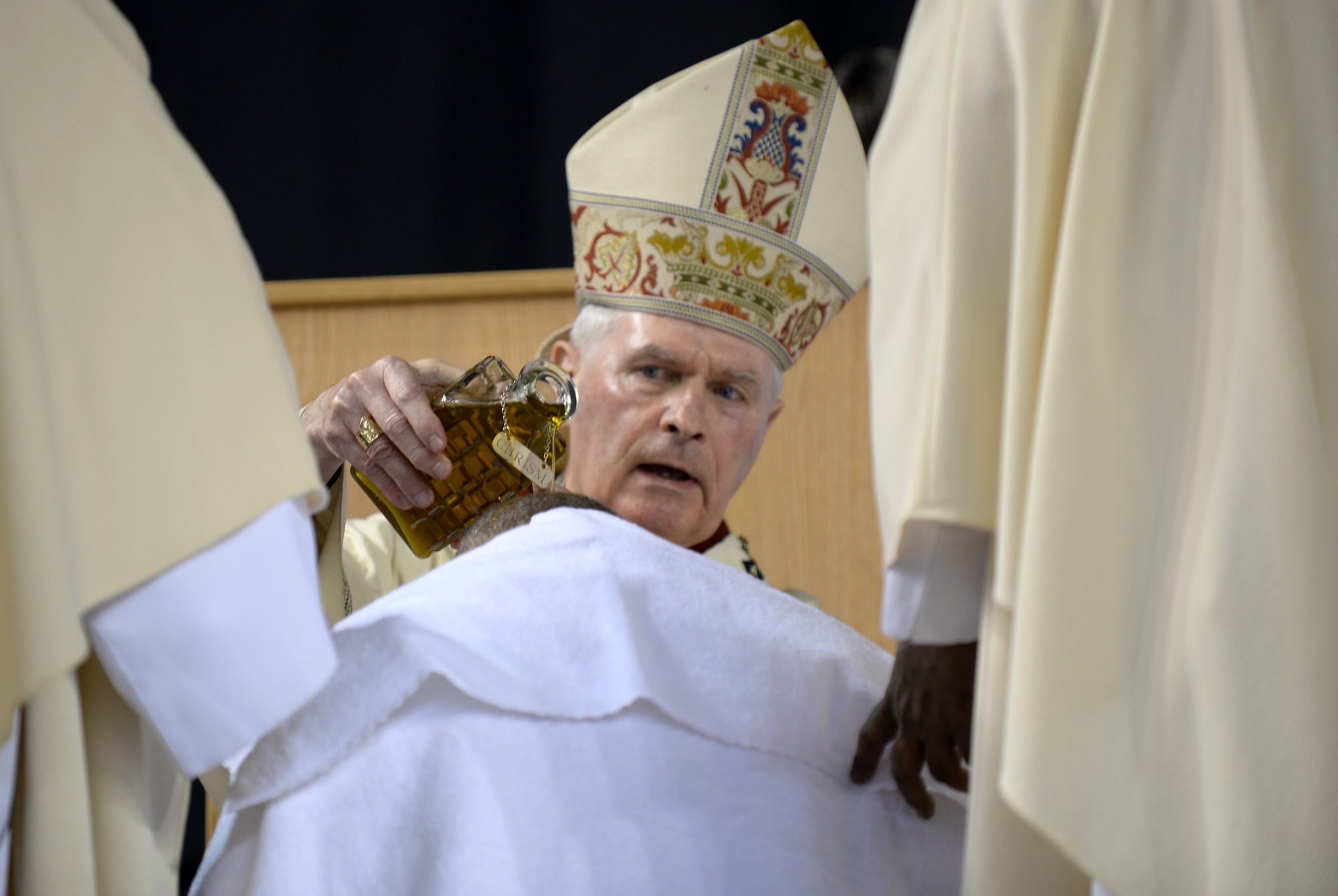Rev. Roger L. Schwietz, Archbishop of Anchorage, Alaska, pours anointing oil on the head of Chaplain (Maj.) Chad Zielinski, the 354th Fighter Wing deputy wing chaplain, ordaining Zielinski the bishop of the Fairbanks Catholic diocese Dec. 15, 2014 at the Carlson Center, Fairbanks, Alaska. Zielinski’s will be responsible for overseeing Catholic interests in an area the size of Texas, much of which isn’t accessible by road. (U.S. Air Force photo by Staff Sgt. Shawn Nickel/Released) 