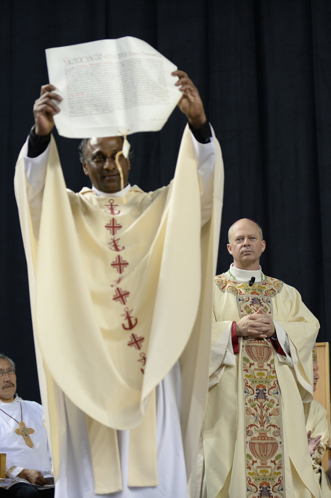 Chaplain (Maj.) Chad Zielinski, the 354th Fighter Wing deputy wing chaplain, watches as a letter from Pope Francis is read to the crowd during a ceremony ordaining him the bishop of the Fairbanks Catholic diocese Dec. 15, 2014 at the Carlson Center, Fairbanks, Alaska. This is the first time an active-duty Airman has been chosen for a position of this magnitude. (U.S. Air Force photo by Staff Sgt. Shawn Nickel/Released)