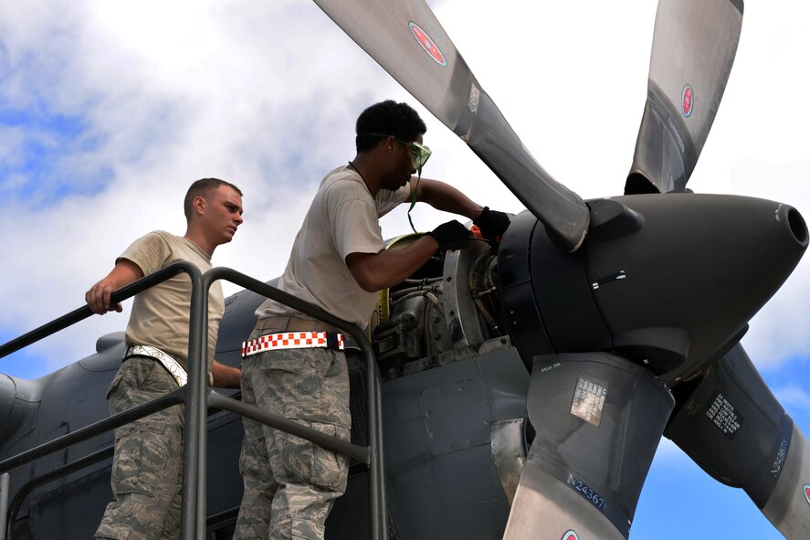 (left to right) Airman First Class Colton Fisher, Engine technician, and Senior Airman Marcus Bost, crew chief, 374th Aircraft Maintenance Group, 374th Airlift Wing, Yokota Air Base, Japan, check oil levels on a C-130H aircraft during Operation Christmas Drop 2014 Dec. 11. Maintainers are integral to the success of any aircraft operation, but especially so on missions away from home station, such as OCD 14, where lack of spare aircraft and limited supplies and personnel make maintaining aircraft more difficult. OCD, a partnership between the 374th Airlift Wing, the 36th Wing at Andersen Air Force Base, Guam and the 515th Air Mobility Operations Wing, Joint Base Pearl Harbor-Hickam, HI, is the longest-running Department of Defense-led humanitarian airlift operation and will provide 25 tons of critical supplies to 56 islands this year. (U.S. Air Force photo by Capt. Mark Lazane/374th Airlift Wing Public Affairs)