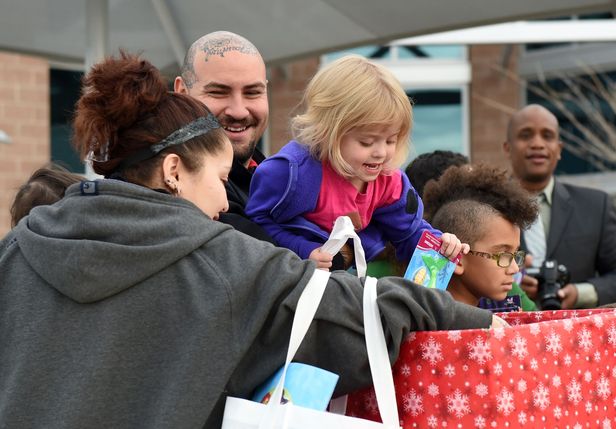 A Team Buckley family picks out gifts at the annual Breakfast with Santa event Dec. 14, 2014, at the Leadership Development Center on base. At the event, Team Buckley had the opportunity to meet Mr. and Mrs. Claus, grab a pancake breakfast and pick out their favorites from a variety of gifts to raise holiday spirit. (U.S. Air Force photo by Airman 1st Class Emily E. Amyotte/Released)