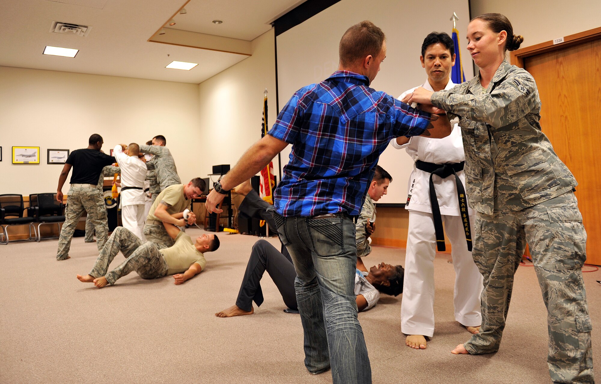 Volunteers participate in a Karate demonstration after an Okinawa cultural seminar on Kadena Air Base, Japan, Dec. 12, 2014. The purpose of the seminar was to provide military members, civilians and family members a chance to learn and respect the history and culture of Okinawa. They also had an opportunity to see and participate in a Karate demonstration. (U.S. Air Force photo by Naoto Anazawa/Released)