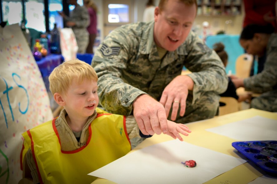 U.S. Air Force Staff Sgt. Brandon Johnson, 822d Base Defense Squadron, and son Brantly, paint together during Winter Wonderland Dec. 12, 2014, at Moody Air Force Base, Ga. Both military and civilian parents participated in the event. (U.S. Air Force photo by Senior Airman Sandra Marrero/Released)
