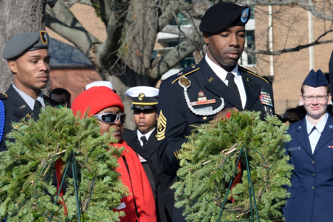 U.S. Army Junior ROTC Cadet Lieutenant Commander Jeremiah Hardy; Diane Davis, former U.S. Army Capt.; and First Sgt. Mundrickus Kelly, 264th Combat Sustainment Support Battalion, 82nd Sustainment Brigade first sergeant, lay a ceremonial wreath in honor of all U.S. Army Soldiers who have died, during the Wreaths Across America Day ceremony at the Hampton National Cemetery in Hampton, Va., Dec. 13, 2014. Wreaths were laid for fallen members of the U.S. Army, Marine Corps, Navy, Air Force, Coast Guard, Merchant Marines and all those who were prisoners of war or missing in action. (U.S. Air Force photo by Staff Sgt. Teresa J. Cleveland/Released)