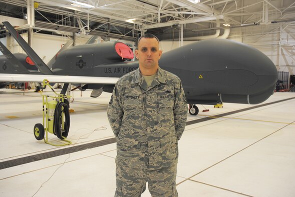 Tech. Sgt. Darrell Pritchett, 69th Maintenance Squadron specialist expediter, poses for a photo Dec. 10, 2014, in front of an RQ-4 Block 40 Global Hawk inside a hangar on Grand Forks Air Force Base, N.D. Pritchett is responsible for directing daily avionics maintenance and coordinating with production superintendents to accomplish scheduled and unscheduled tasks for the unmanned aircraft. The 14-year-veteran from Hannibal, Mo., was named the Grand Forks AFB Warrior of the Week for the third week of December 2014. (U.S. Air Force photo/Staff Sgt. Luis Loza Gutierrez)
