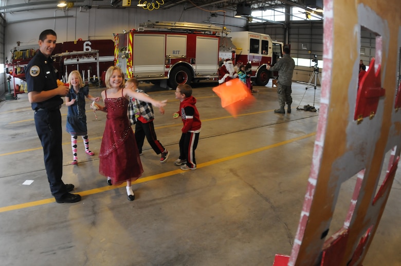 Kingsley Field Firefighter Brett Hulstrom chaperones a beanbag toss at the firehouse Dec. 7, 2014 at the 173rd Fighter Wing in Klamath Falls, Ore. The game was part of an alternative for the annual children’s carnival which was cancelled this year due to the main hangar renovation. (U.S. Air National Guard photo by Tech. Sgt. Jefferson Thompson/released)