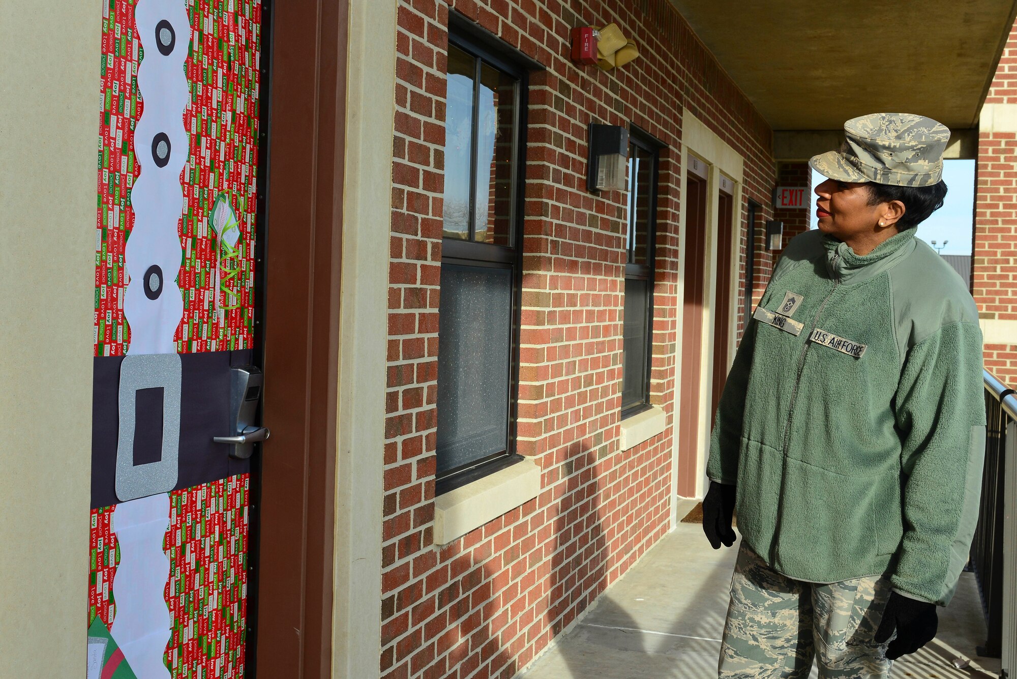 U.S. Air Force Chief Master Sgt. Trae King, 633rd Air Base Wing command chief, looks at a decorated door during the Dorm Door Decorating Contest at Langley Air Force Base, Va., Dec. 12, 2014. Airmen living in the on-base dormitories were encouraged to decorate their doors with a holiday theme. (U.S. Air Force photo by Senior Airman Kimberly Nagle/Released)