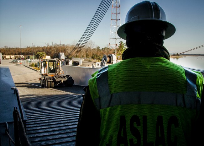 Don Strunk, Army Strategic Logistical Activity – Charleston manager, waits as vehicles are loaded onto the USNS Watkins (T-AKR 315), Dec. 15, 2014, at Joint Base Charleston, S.C. Once loaded with more than 1,200 pieces of military equipment, the 950-foot long ship will embark to a prepositioned location overseas. (U.S. Air Force photo / Senior Airman Tom Brading)