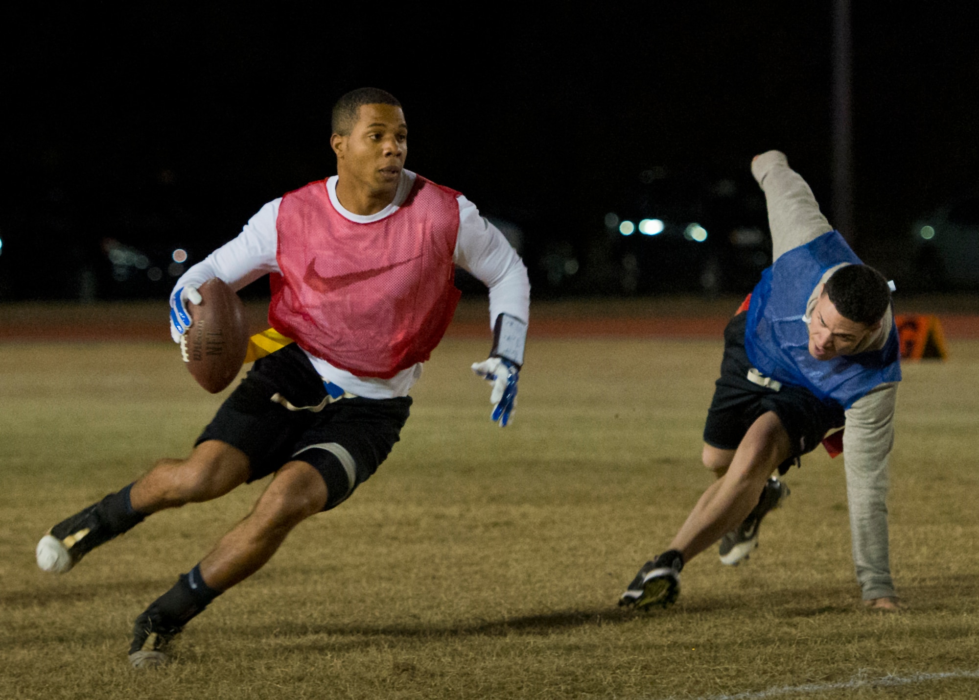 Savier Stephens, with the Armament Directorate team, runs by a 96th Security Forces Squadron defender during the base intramural flag-football championship game Dec. 11 at Eglin Air Force Base, Fla.  The EB team won in an overtime battle 25-24 and repeated as base champions.  (U.S. Air Force photo/Samuel King Jr.)