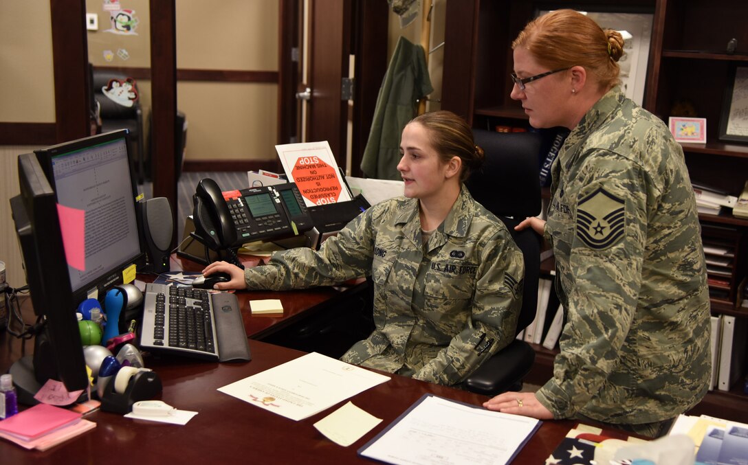 Master Sgt. Caroline Vaughn, 341st Missile Wing functional manager, right, helps Senior Airman Sandra Long, 341st Logistics Readiness Squadron administration journeyman, with a retirement decoration Dec. 15. Administrators are mainly commander’s support and their duties include administrative support (publications and forms), human resources (leave, awards and decorations), commander programs (fitness management) and postal service. (U.S. Air Force photo/Airman 1st Class Joshua Smoot)