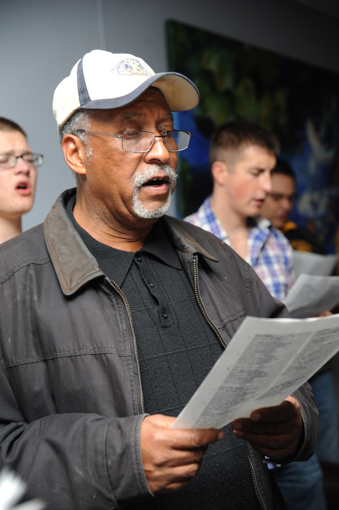 Retired Maj. Laplace Jackson, Jr., Keesler gospel choir member, participates in Christmas caroling at the Levitow Training Support Facility Fishbowl Dec. 12, 2014, at Keesler Air Force Base, Miss.  Following the Christmas caroling, hot chocolate and cookies were available to everyone in attendance. (U.S. Air Force photo by Kemberly Groue)