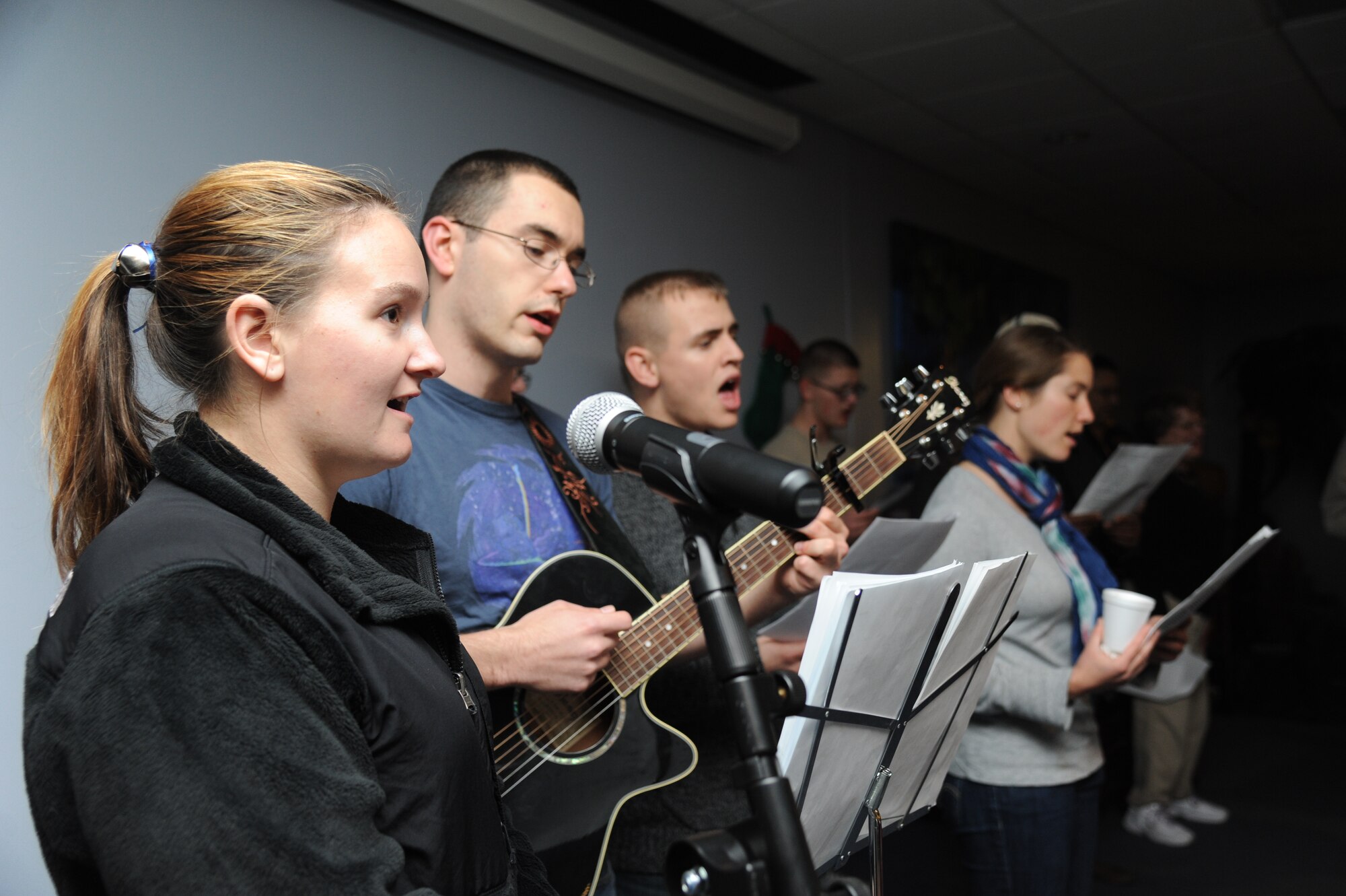 Second Lts. Emily Murch and Jared Loving, 333rd Training Squadron undergraduate cyber space training students, lead Keesler personnel in singing Christmas carols at the Levitow Training Support Facility Fishbowl Dec. 12, 2014, at Keesler Air Force Base, Miss.  Following the Christmas caroling, hot chocolate and cookies were available to everyone in attendance. (U.S. Air Force photo by Kemberly Groue)