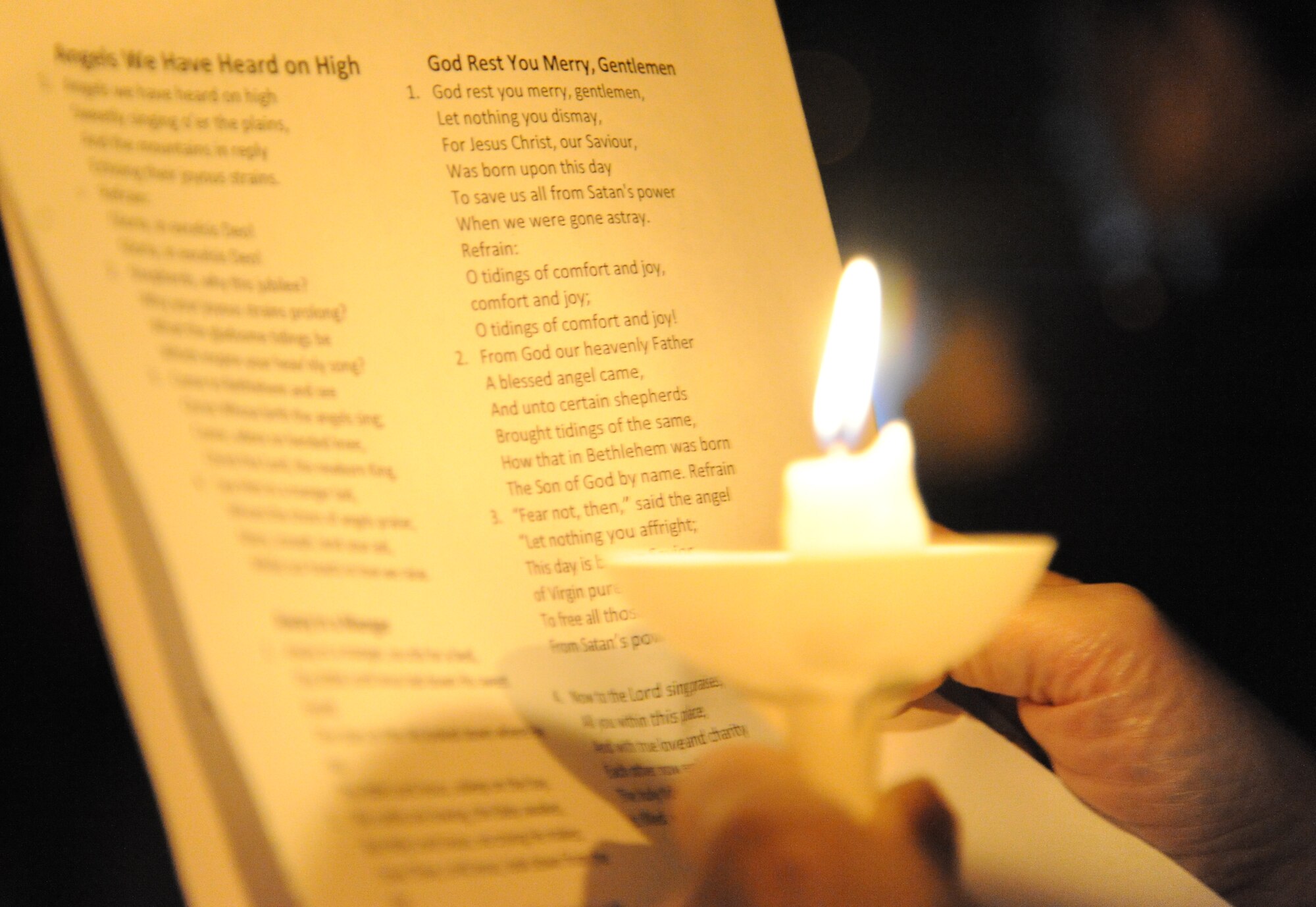 A candle illuminates a song list while Keesler personnel make their way around theTriangle Courtyard singing Christmas carols Dec. 12, 2014, at Keesler Air Force Base, Miss. Following the Christmas caroling, hot chocolate and cookies were available to everyone in attendance. (U.S. Air Force photo by Kemberly Groue)