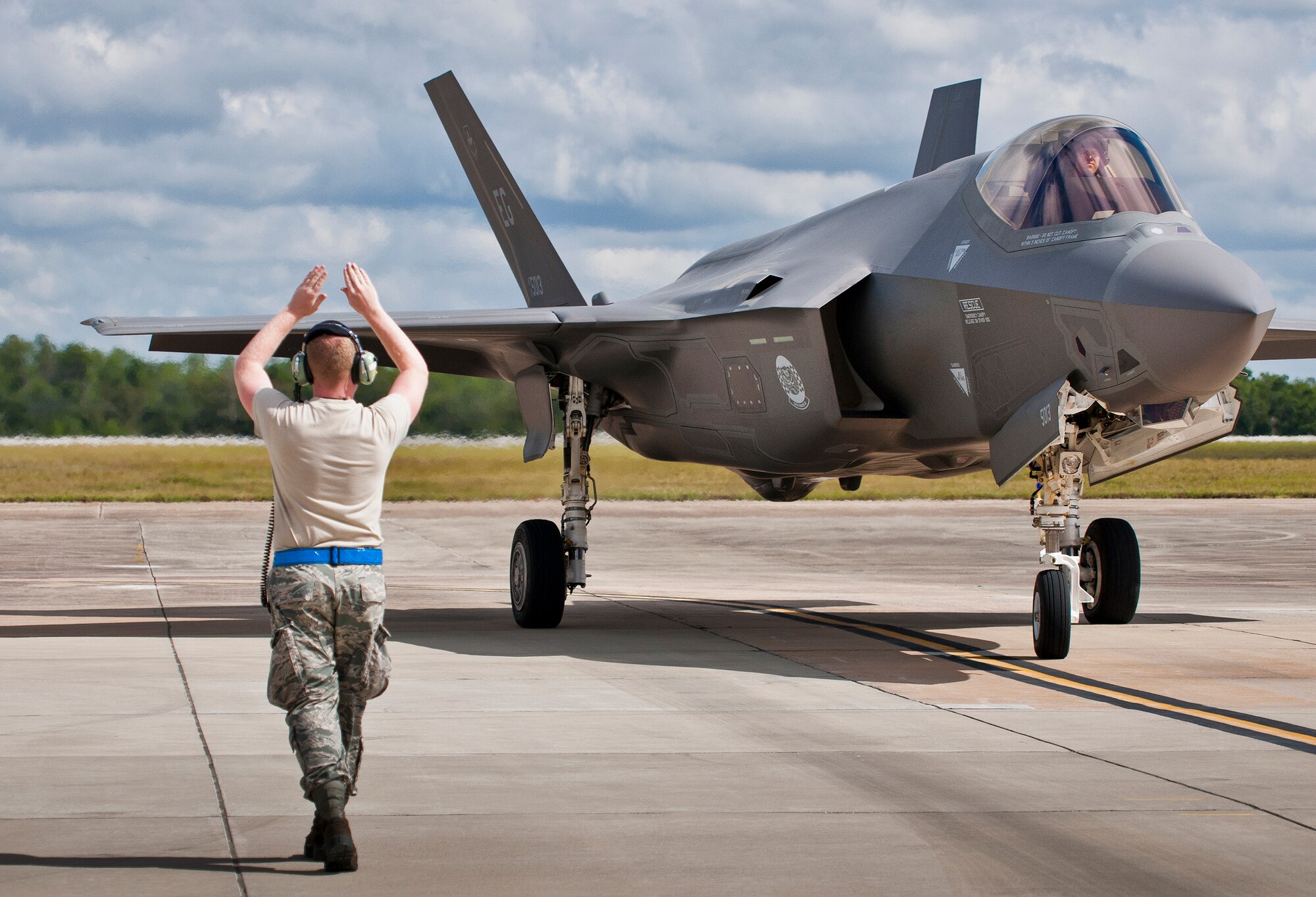 Senior Airman Herbert Tucker, 33rd Aircraft Maintenance Squadron, marshals in an F-35A Lightning II for a hot pit refueling session at Eglin Air Force Base, Fla.  All of the F-35 variants use the refueling areas in conjunction with the 96th Logistics Readiness Squadron’s fuels flight. (U.S. Air Force photo/Samuel King Jr.)  