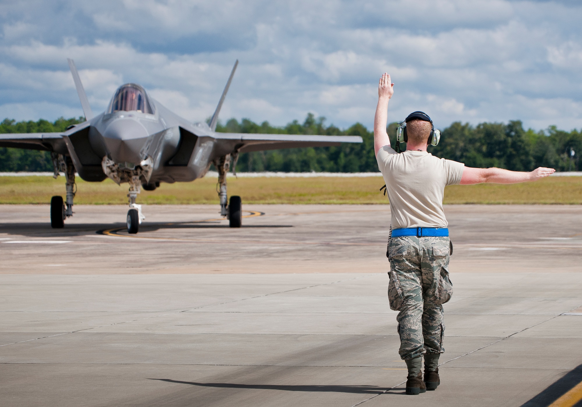 Senior Airman Herbert Tucker, 33rd Aircraft Maintenance Squadron, marshals in an F-35A Lightning II for a hot pit refueling session at Eglin Air Force Base, Fla.  All of the F-35 variants use the refueling areas in conjunction with the 96th Logistics Readiness Squadron’s fuels flight. (U.S. Air Force photo/Samuel King Jr.)  
