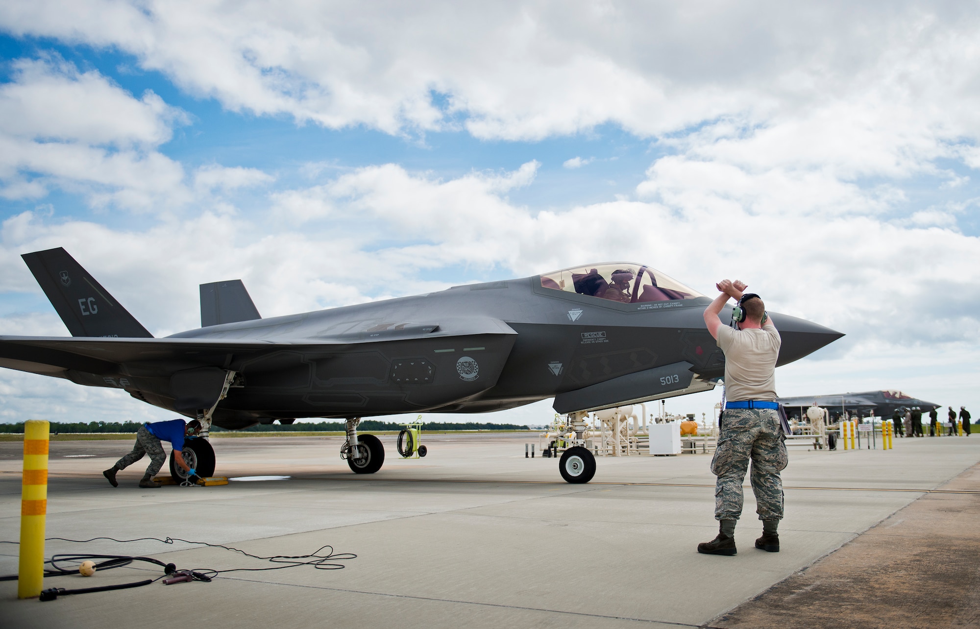 Senior Airman Herbert Tucker, 33rd Aircraft Maintenance Squadron, marshals in an F-35A Lightning II for a hot pit refueling session at Eglin Air Force Base, Fla.  All of the F-35 variants use the refueling areas in conjunction with the 96th Logistics Readiness Squadron’s fuels flight. (U.S. Air Force photo/Samuel King Jr.)  