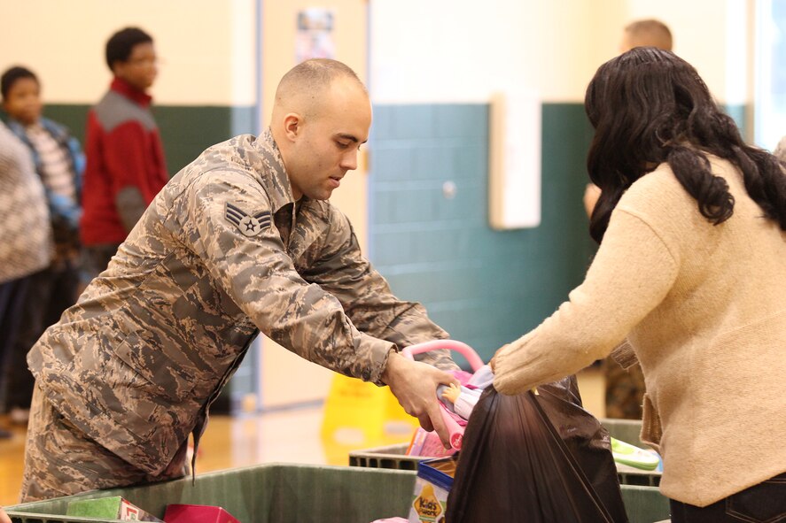 DAYTON, Ohio - Senior Airman Trenton Shaffer, 445th Aircraft Maintenance Squadron crew chief, hands out toys to recipients during the Toys for Tots program at Westwood Elementary School, Dayton, Ohio Dec. 6, 2014. Approximately 30 Reserve Airmen and Reserve Force Marines from the 445th Airlift Wing and the Military Police Company C, Wright-Patterson Air Force Base, Ohio handed out toys. The mission of the U. S. Marine Corps Reserve Toys for Tots Program is to collect new, unwrapped toys during October, November and December each year, and distribute those toys as Christmas gifts to less fortunate children in the community in which the campaign is conducted. Over its life span, the Marine Toys for Tots Program distributed over 469 million toys to over 216 million less fortunate children. (U.S. Air Force photo/Tech. Sgt. Patrick O'Reilly)