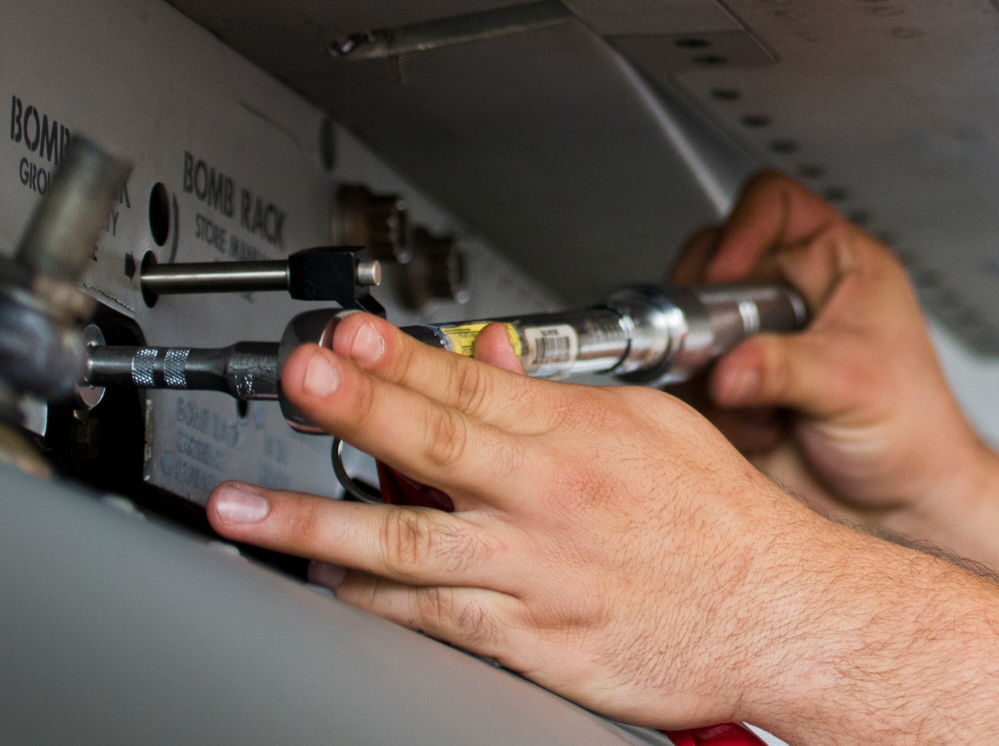 Airman 1st Class Giovan Buffalini-Balla, from 96th Aircraft Maintenance Squadron Red, secures a bolt on the F-15 Eagle’s bomb rack during the 96th Maintenance Group’s quarterly weapons load crew competition Dec. 5 at Eglin Air Force Base, Fla.  The Red F-15 team won out over the 96th Aircraft Maintenance Squadron’s Blue F-16 team.  (U.S. Air Force photo/Samuel King Jr.)