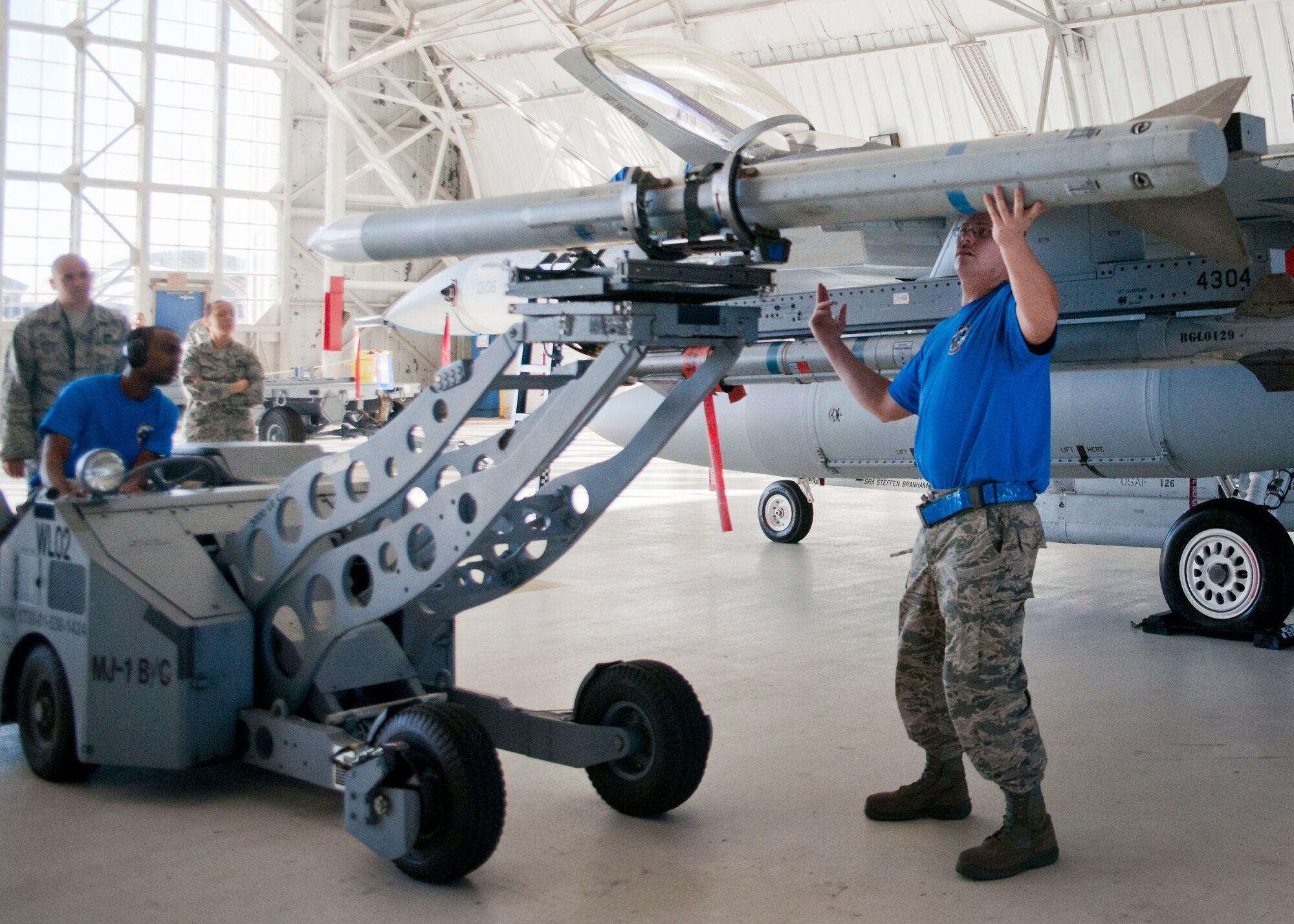 Staff Sgt. Steven Guiette, 96th Aircraft Maintenance Squadron Blue, motions for the AIM-120 to be moved forward during the 96th Maintenance Group’s quarterly weapons load crew competition Dec. 5 at Eglin Air Force Base, Fla.  The Blue crew battled the 96th Aircraft Maintenance Squadron’s Red F-15 crew for quickest and most accurate load of an AIM-9X and an AIM-120 on their respective aircraft.  (U.S. Air Force photo/Samuel King Jr.)