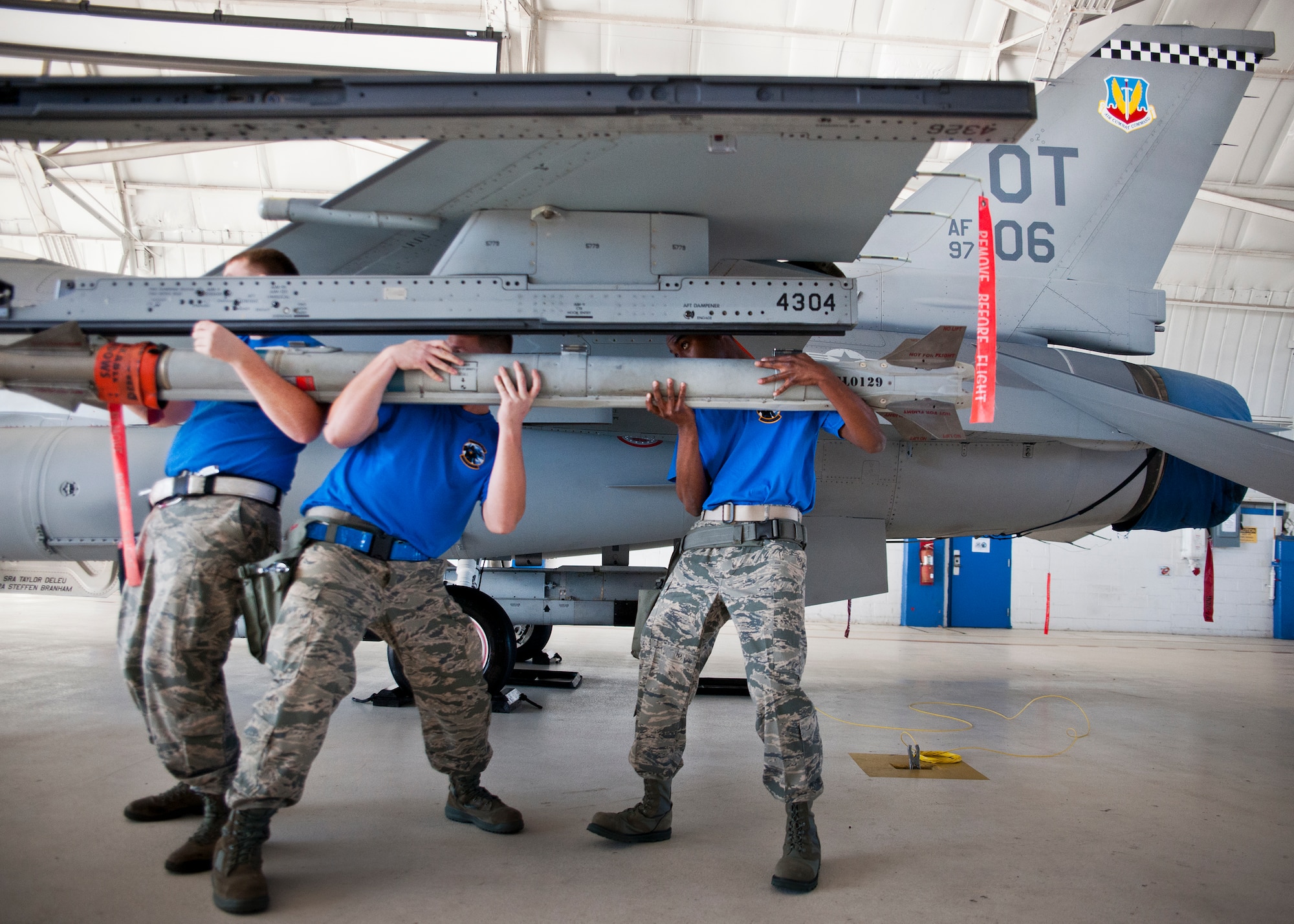 The 96th Aircraft Maintenance Squadron Blue crew lifts the AIM-9X into place during the 96th Maintenance Group’s quarterly weapons load crew competition Dec. 5 at Eglin Air Force Base, Fla.  The Blue crew battled the 96th Aircraft Maintenance Squadron’s Red F-15 crew for quickest and most accurate load of an AIM-9X and an AIM-120 on their respective aircraft.  (U.S. Air Force photo/Samuel King Jr.)