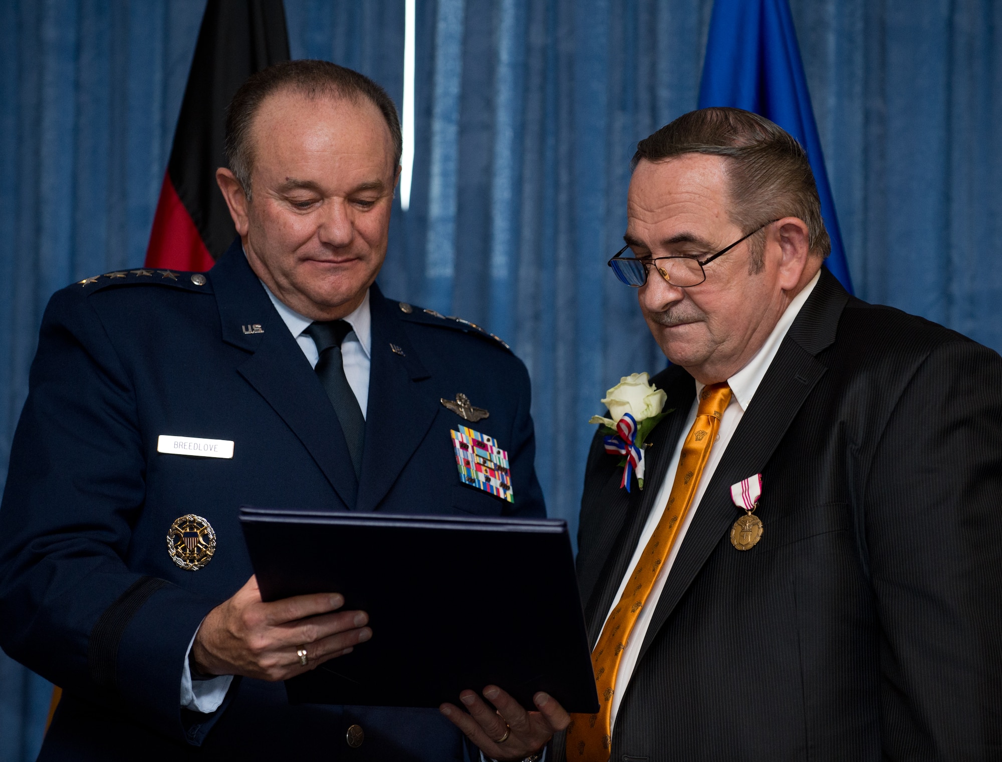 Gen. Philip M. Breedlove, commander of U.S. European Command and Supreme Allied Commander Europe, and John Mace read a certificate of service during his retirement ceremony Dec. 12, 2014, at Ramstein Air Base, Germany. Mace retired from the military after 25 years and retired again from civil service after 29 years. Mace was the special operations medical officer for the 86th Medical Group, where he provided comprehensive medical care to the 86th Airlift Wing, U.S. Air Forces in Europe, joint service partners and numerous embassies and consulates throughout Europe, Africa and the Middle East. (U.S. Air Force photo/Senior Airman Jonathan Stefanko)