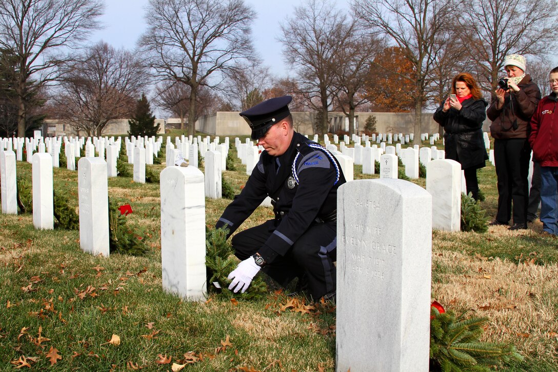 Kevin Haley, a police officer from Portland, Maine, lays a wreath against the headstone of his brother, William Haley, during Wreaths Across America at Arlington National Cemetery in Arlington, Va., Dec. 13, 2014. Kevin Haley is an advisory board member of Wreaths Across America, the Maine-based nonprofit that shipped 700,000 wreaths to Arlington.