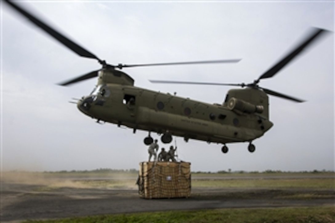 U.S. soldiers attach cargo to a CH-47 Chinook helicopter on Roberts International Airport in Harbel, Liberia, Dec. 12, 2014. The mission was to airlift incinerators to a new Ebola treatment unit built in support of Operation United Assistance.