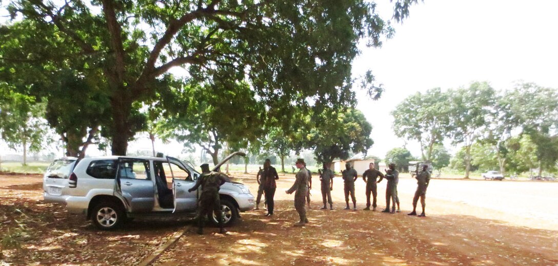 Service members with the Togolese Armed Forces conduct a vehicle search during a theater security cooperation engagement with U. S. Marines in Lome, Togo, Dec. 3, 2014. In Togo, the Marines trained alongside 20 students from the Togoloese Army, Air Force, Navy and the Gendarmerie forces. Training in both regions focused on weapons safety and handling, rules of engagement, escalation of force, personnel and vehicle searches, vehicle entry points as well as entry control points—ending with a final exercise that tested the collective tactical knowledge learned over the course of the training engagement. Marines with SPMAGTF Crisis Response-Africa conducted the TSC engagement to help develop and enhance armed sentry skills sharing tactics, techniques and procedures with the Togolese Armed Forces. (Courtesy Photo)