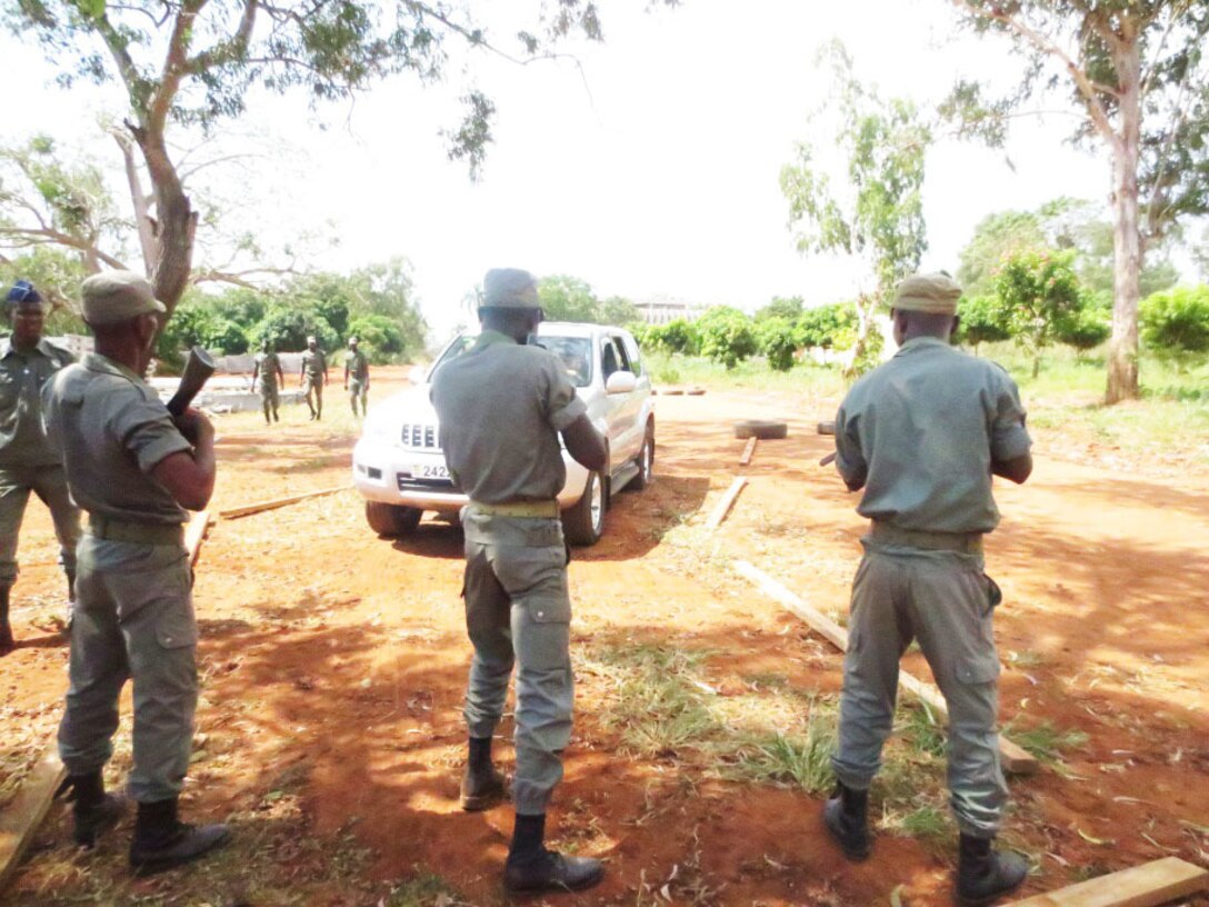 Service members with the Togolese Armed Forces use escalation of force procedures and guide a vehicle through an entry control point (ECP) in order to conduct a vehicle search during a theater security cooperation engagement with U. S. Marines in Lome, Togo, Dec. 4, 2014. In Togo, the Marines trained alongside 20 students from the Togoloese Army, Air Force, Navy and the Gendarmerie forces. Marines with SPMAGTF Crisis Response-Africa conducted the TSC engagement to help develop and enhance armed sentry skills sharing tactics, techniques and procedures with the Togolese Armed Forces. (Courtesy Photo)