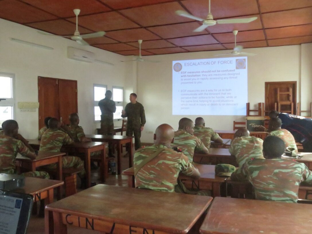 Gunnery Sgt. Gabriel Burns gives a class on Escalation of Force to service members with the Benin Navy in Contonou, Benin, Nov. 25, 2014. Burns, an Auburn, Ind. Native with SPMAGTF Crisis Response-Africa conducted a theater security cooperation engagement to help develop and enhance armed sentry skills as the Beninese Navy is preparing to deploy on a peace-keeping mission to the Democratic Republic of Congo (DRC) where they will be standing sentry duties. (Courtesy Photo)