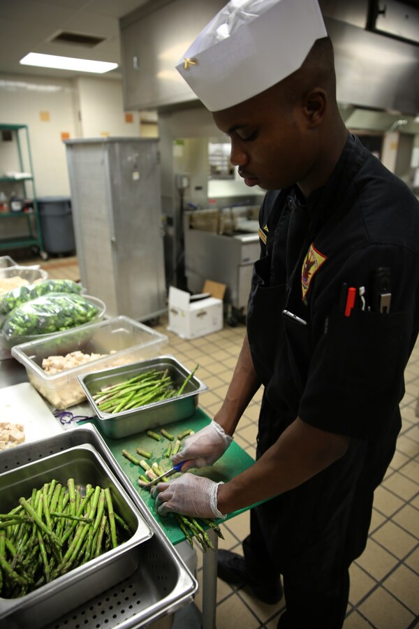 Lance Cpl. Jaylen M. Thomas stands at rest while judges critique his meal during the Chef of the Quarter competition at Marine Corps Air Station Cherry Point, N.C., Dec. 12, 2014. Thomas prepared the winning meal of fried chicken, dirty mashed potatoes, sweet cream corn, asparagus and fried Oreos. Thomas, a native of Atlanta, is a food service specialist with Headquarters and Headquarters Squadron.